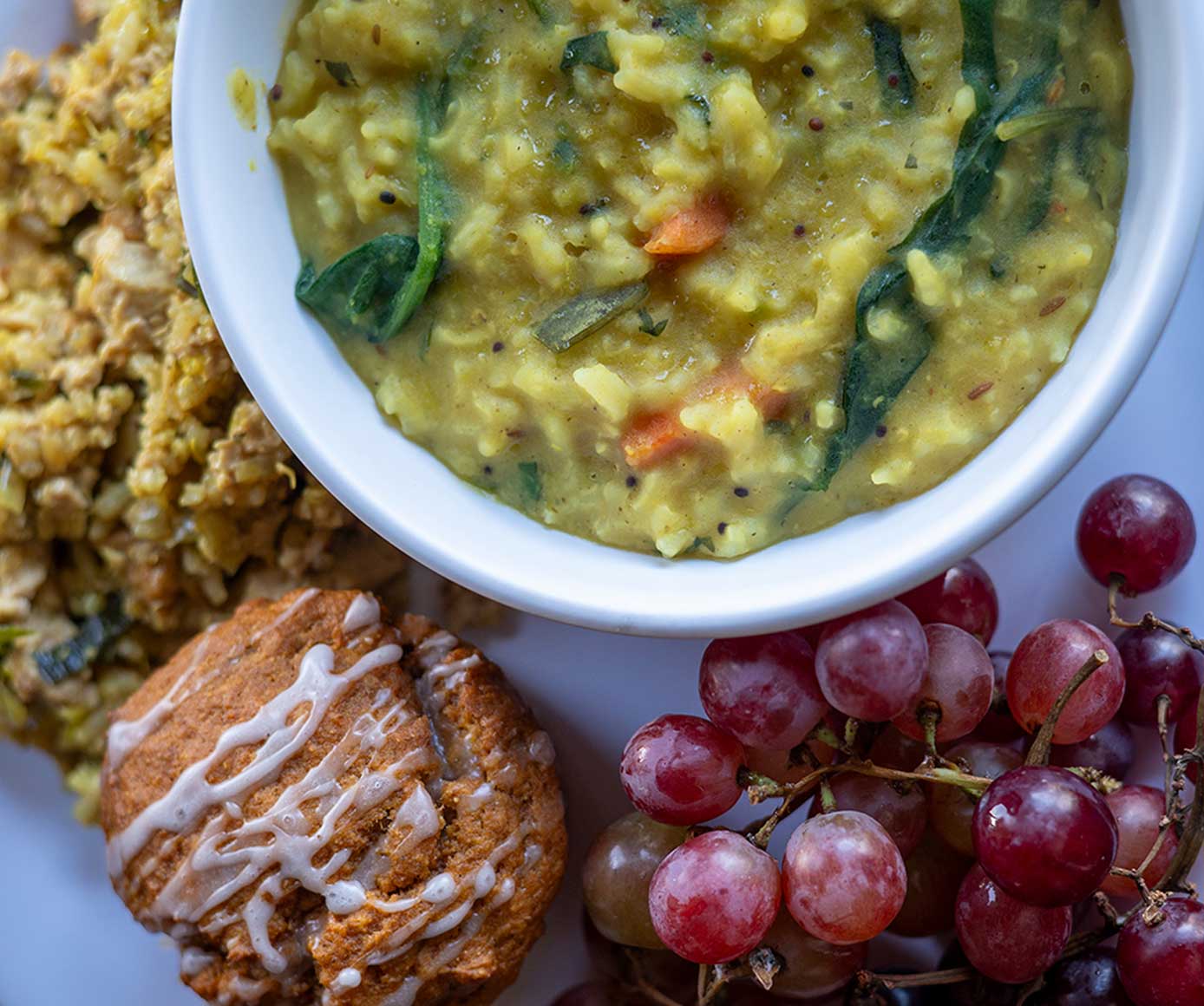 Colorful vegetarian meal consisting of soup, side dish, fresh fruit and natural desert.