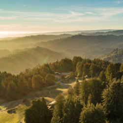 Panoramic aerial view of Mt. Madonna Retreat Center surrounded by forest, overlooking Monterey Bay, California.